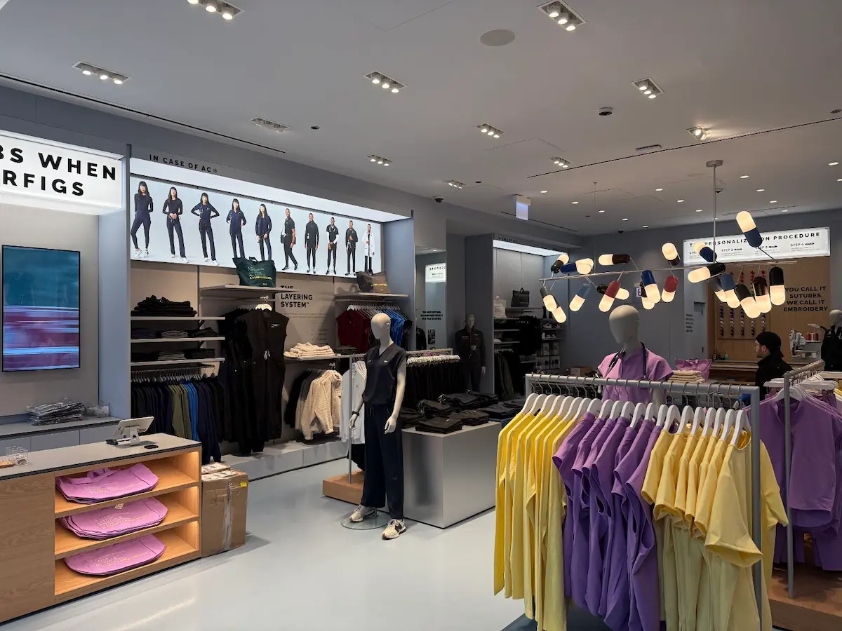 Retail store interior featuring clothing displays, LED lighting design, and a modern aesthetic, showcasing product arrangement and brand standards for retail buildout.